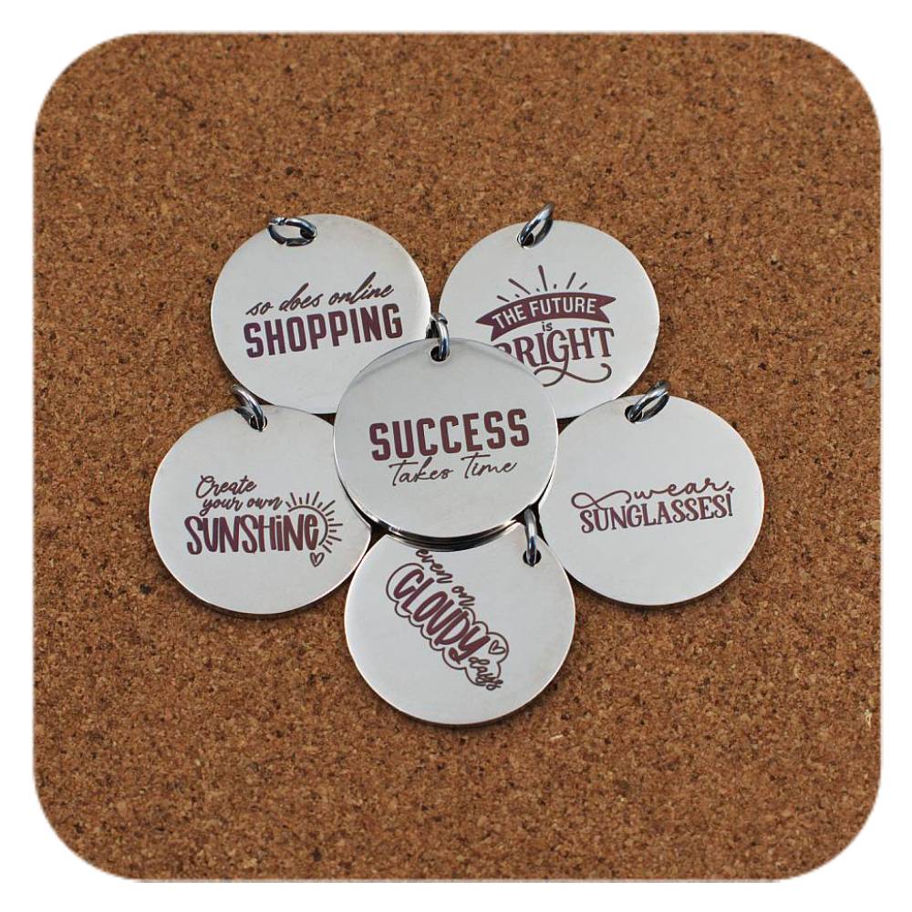 Silver pendants with different Light-Hearted Inspiration designs on cork background