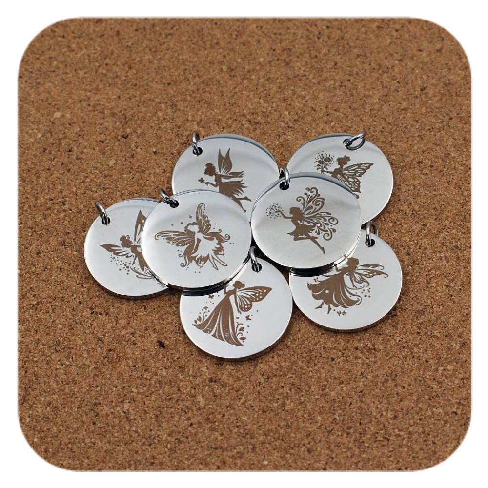 Silver pendants with different Enchanted Fairy designs on cork background