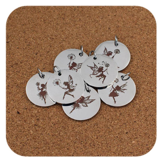 Silver pendants with different Fairy & Dandelion designs on cork background