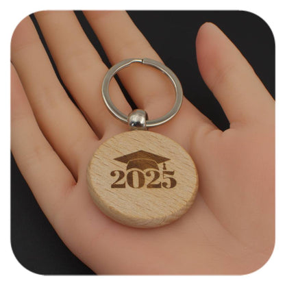 Wooden keyring with Graduation Cap 2025 design held in a hand
