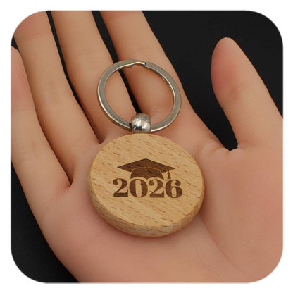 Wooden keyring with Graduation Cap 2026 design held in a hand