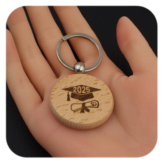 Wooden keyring with Graduation Cap Diploma 2025 design held in a hand